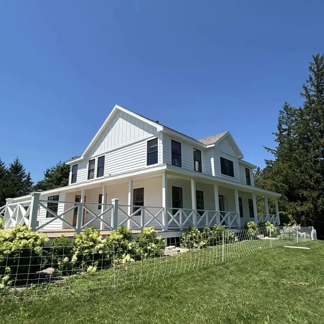 Freshly painted white two-story home with wraparound porch in Rochester, Minnesota